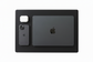 A brown leather desk mat with rounded corners, shown flat-lay with a closed black Apple MacBook, a black Apple iPhone, and a white wireless earbud case on a white background.