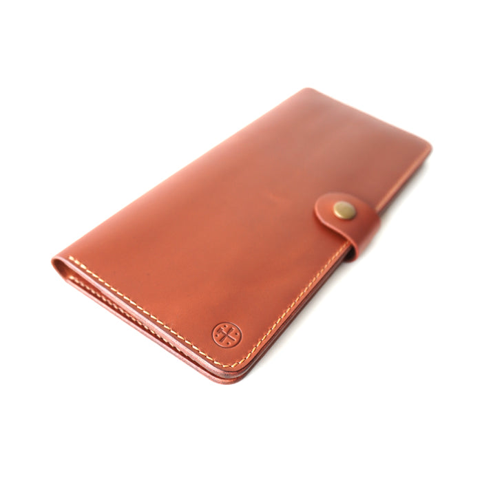 Brown leather cheque wallet with a antique button on a white background