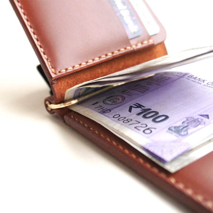 Brown leather wallet with Indian currency notes inside on a white background